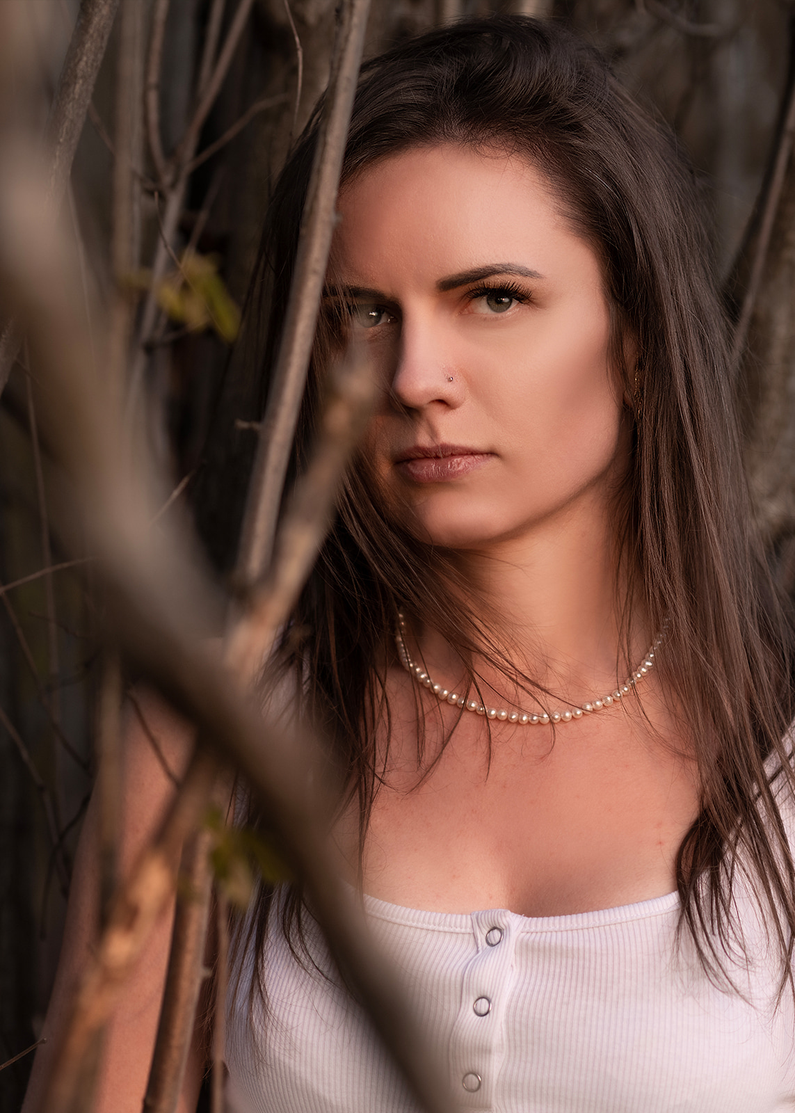 Close outdoor portrait of a brunette woman looking directly at the camera.