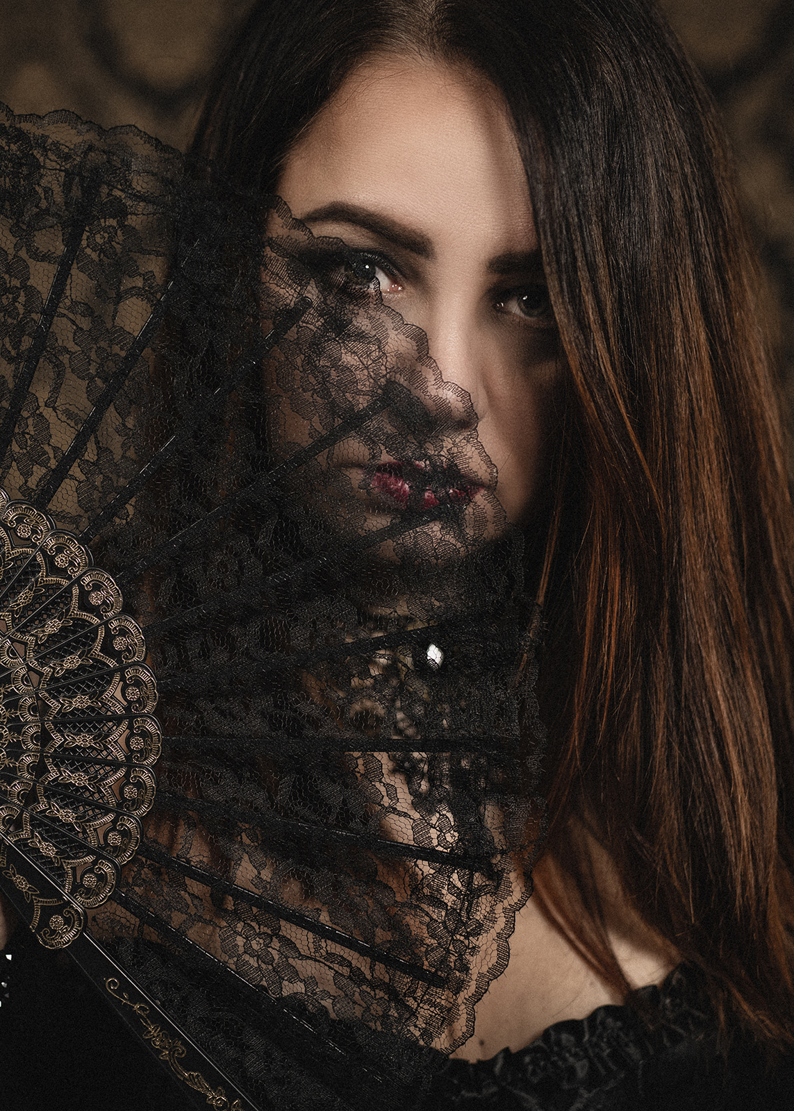 Close portrait of a woman partially covered by black lace.