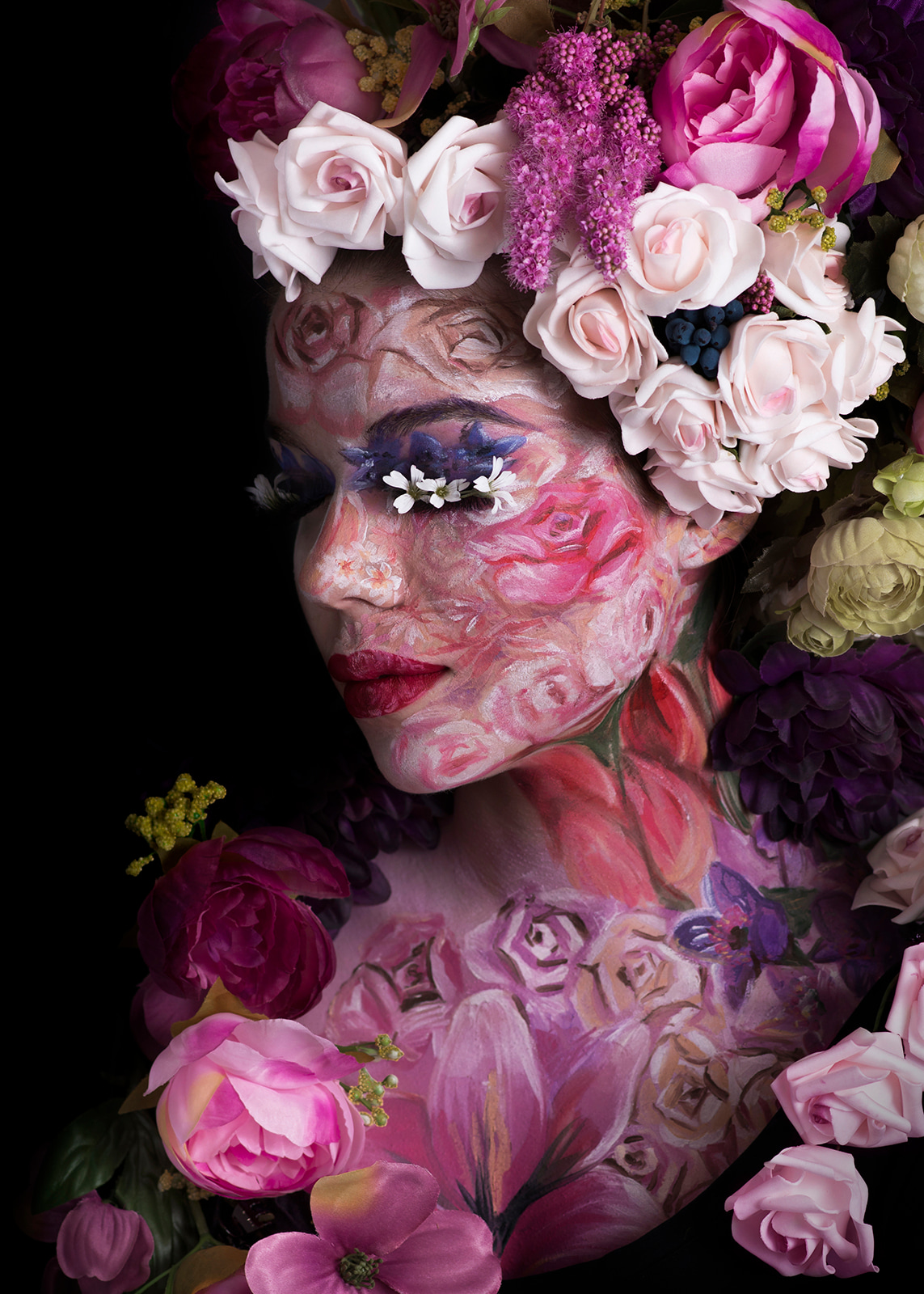 Artistic portrait of a woman surrounded by flowers with painted floral makeup.